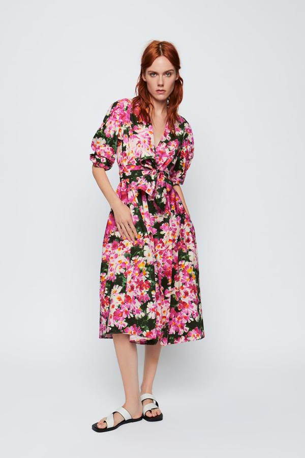Vestido de línea evasé con escote pico y manga larga de Zara (49,95 euros). Lleva un cinturón en el mismo tejido, estampado con grandes flores en color rosa sobre fondo verde.
