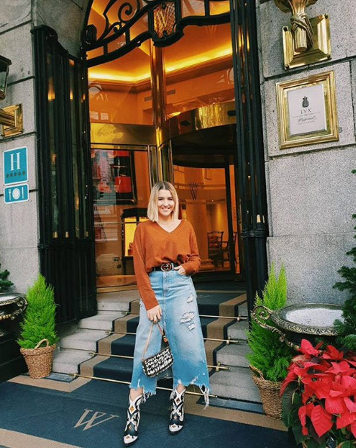 Alba Díaz posó así de oroginal con una falda vaquera de Zara midi y un jersey de pico en color camel. Dio el toque distintivo al añadir unas botas de estilo cowboy y un bolso de Louis Vuitton.