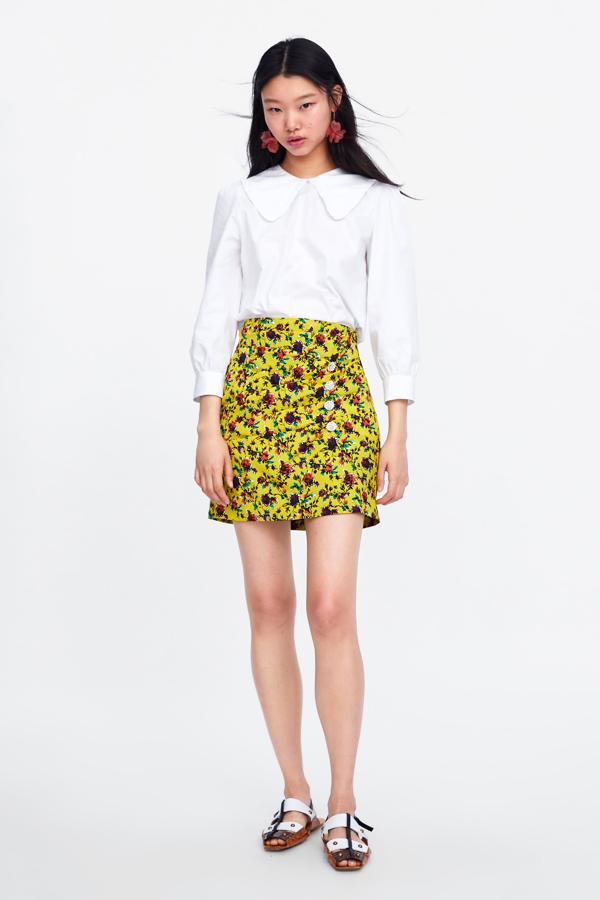 Con fondo amarillo y flores de colores, su forma drapeada y botones joya hace que se sirva tanto para el día como para la noche. Es de Zara (39,95 euros).