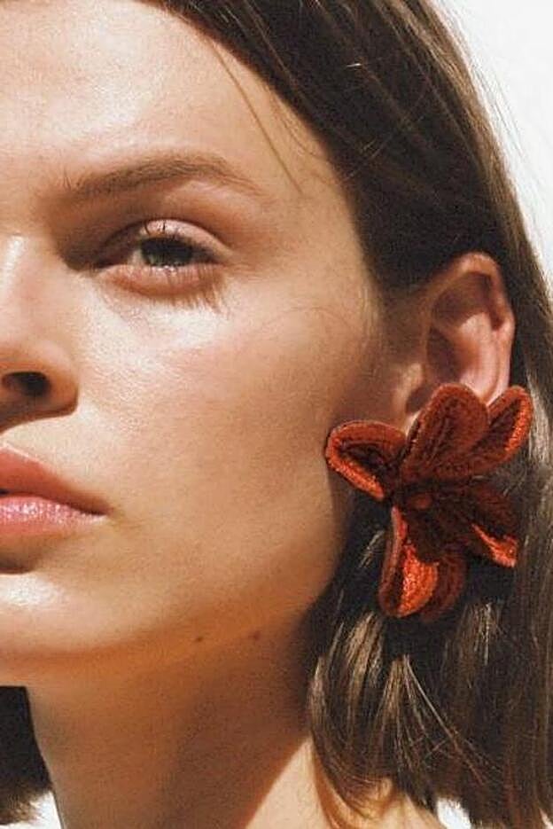 Pendientes de Zara con forma de flor, en tela bordada (12,95 euros).