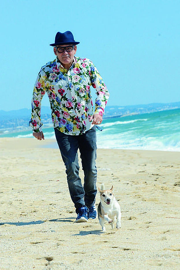 José Corbacho pasea a su perro por la playa.