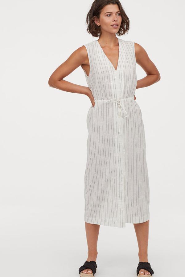 Vestido en tejido de viscosa con escote de pico, costura con cordón de ajuste en la cintura y abertura central delante. Va sin forrar (29,99 euros).