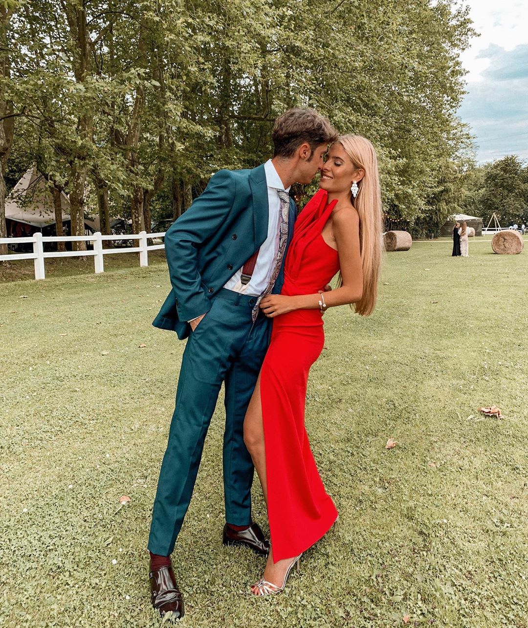 Teresa Andrés, acompañada por su novio Ignacio Ayllón, también de rojo, con un elegante diseño de Atelier Fernando Claro. La raja lateral y el cuerpo del vestido son lo más original.