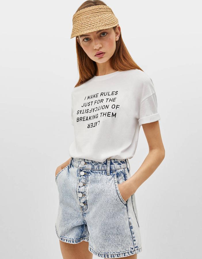 Camiseta blanca con estampado (7,99 euros) y short denim básico con cinco bolsillos, trabillas y cierre con botones (22,99 euros).