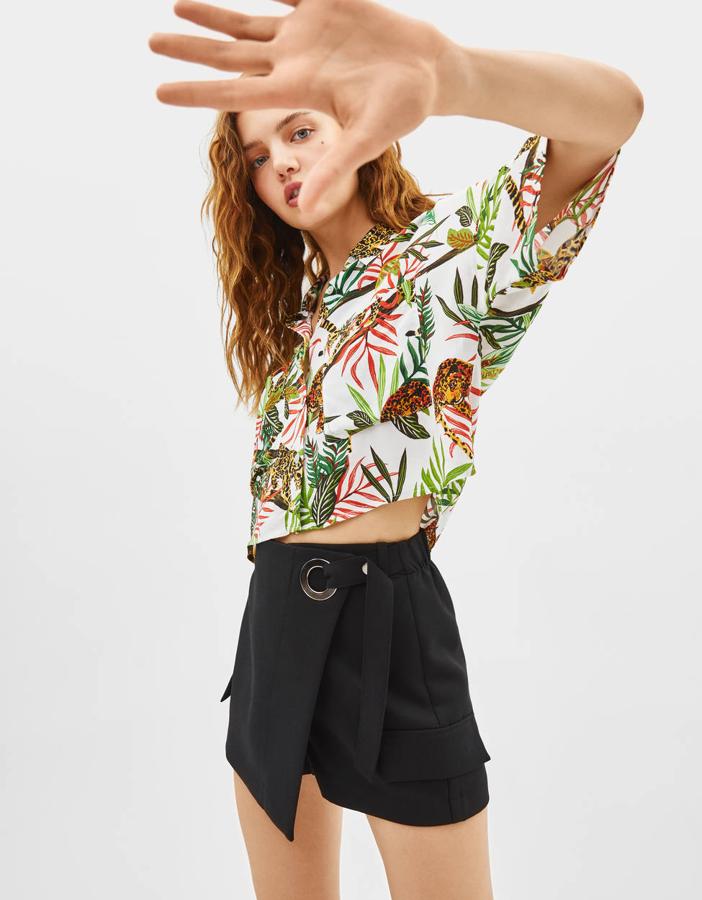 Falda pantalón con cinturón, hebilla metálica y bolsillos (19,99 euros) y camisa con estampado tropical (15,99 euros).