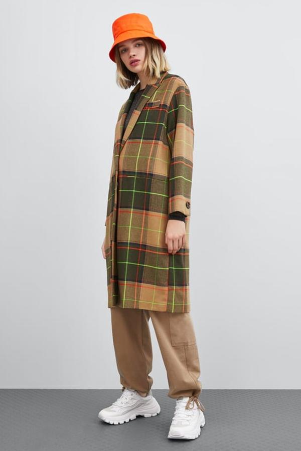 Abrigo amplio con cuello y solapa de manga larga. Lleva bolsillos frontales de vivo y, cierre delantero con botones (Zara, 39,99 euros).