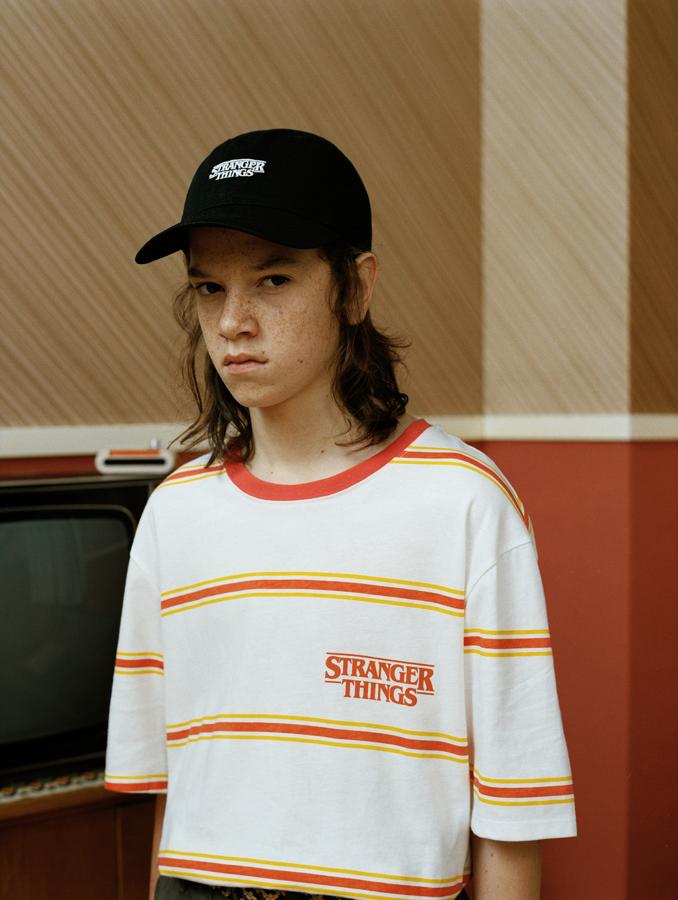 Camiseta 'Stranger Things' de rayas amarillas y naranjas con logo de la serie, de manga corta y rib en cuello ( 15,99 euros en Pull&Bear ).