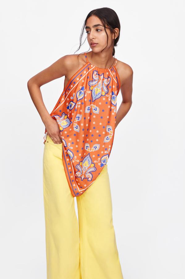 El naranja es uno de los colores del verano y el estampado de pañuelo le da el toque perfecto a este top que se abrocha al cuello, 7,99 euros.