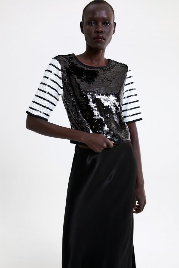 Un top de lentejuelas con el cuerpo negro y las mangas de rayas marineras. Es perfecto para el día con unos vaqueros o para la noche con una falda de raso. Cuesta 9,99 euros.