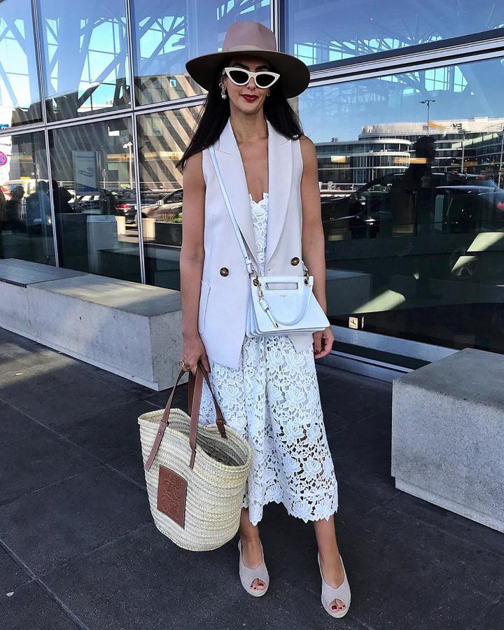 Otra de las utilidades del chaleco es quitarle importancia a vestidos más formales. Como este de encaje blanco, al que con el chaleco y bolso cesta (en este caso, de Loewe) le da el toque veraniego perfecto para poder llevarlo a diario.
