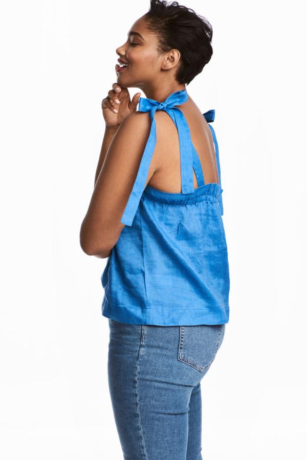 Top en tejido de lino con tirantes de anudar. Lleva un elástico adornado con un ribete de volantes en la espalda y lo puedes comprar en H&M por 14,99 euros (costaba 29,99 euros).