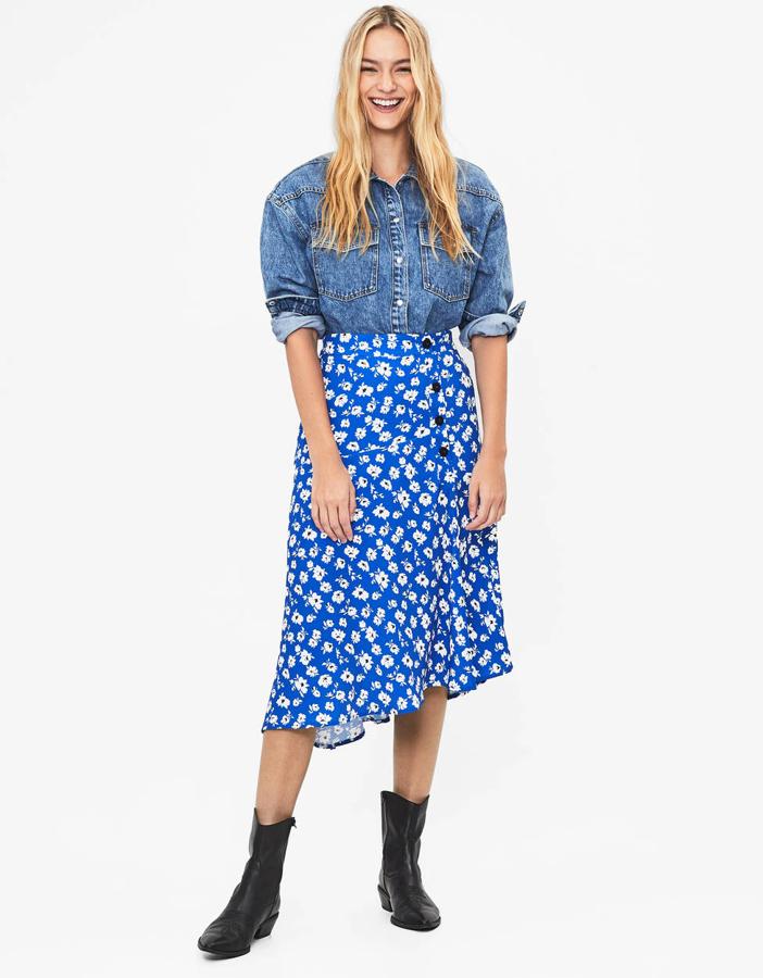 Fantástica falda de azul intenso con un estampado de flores pequeñas y cierre con una hilera con botones en un lateral (Bershka, 19,99 euros).
