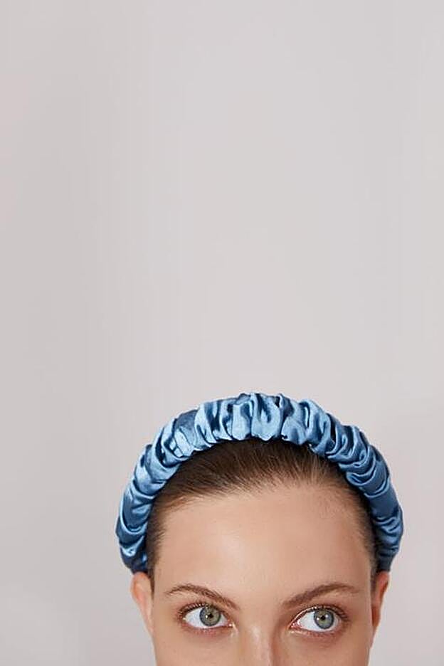 Diadema forrda de tela azul con efecto brillo.