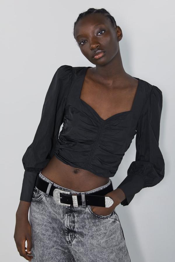 Cuerpo con escote a pico y manga larga acabada con botones: 25,95 euros en Zara.