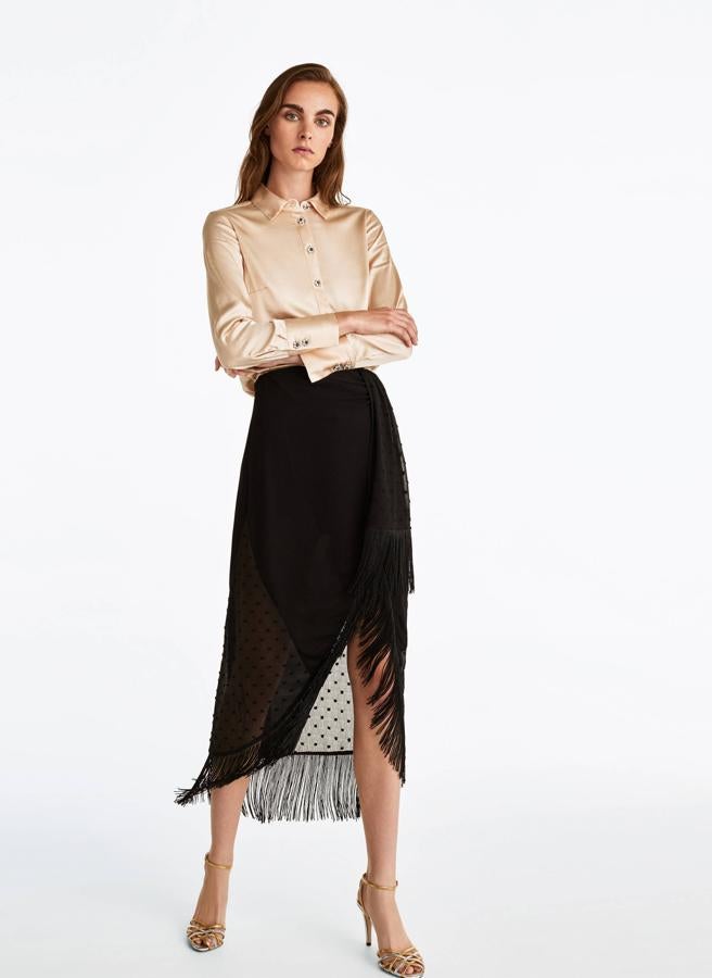 Esta falda de silueta 'wrap' en plumeti negro rematada con flecos merece una mención aparte, por eso escribimos este artículo en el que la nombrábamos la ' falda de invitada de la temporada '. Es de Uterqüe, y cuesta 89 euros.