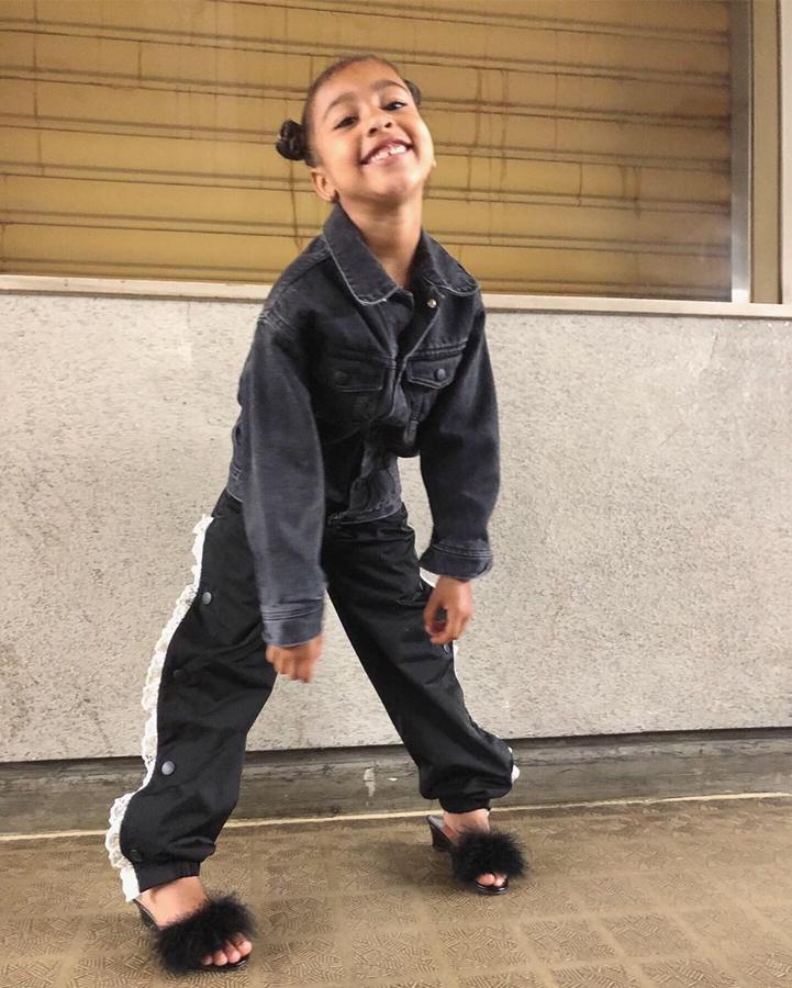 North no solo se inspira en los looks de su madre, Kim Kardashian, también en los estilismos de chándal de su padre, Kanye West. En este caso parece sencillo, una chaqueta vaquera negra y unos pantalones de deporte, pero con detalle de encaje en los laterales. Y, eso sí, sus sandalias de tacón y plumas que no falten, se las pone con todo. ¿Vuelve el chándal con tacones? ¿Marcará esta niña tendencia? Esperemos que no.
