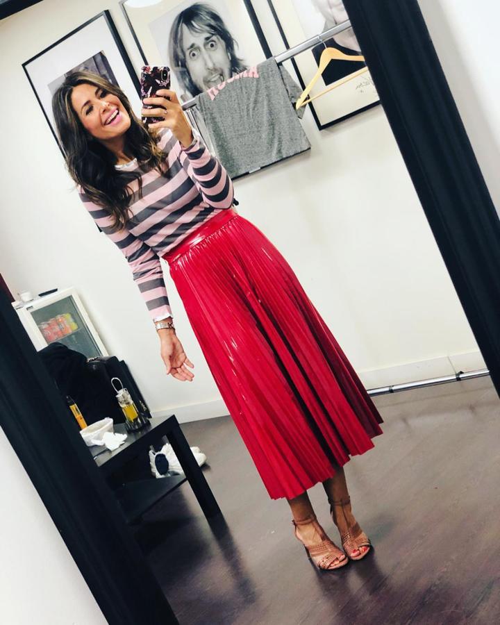 Nuria Roca se hizo con  la falda efecto vinilo que mejor sienta  en color rosa y la combinó con un jersey de rayas.