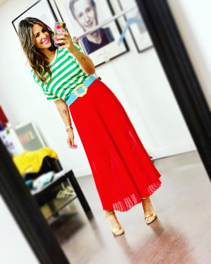 Nuria Roca lo dio todo con este atrevido look al combinar una falda roja con una camiseta de rayas verde y blanca. Añadió un cinturón azul y unas sandalias doradas.