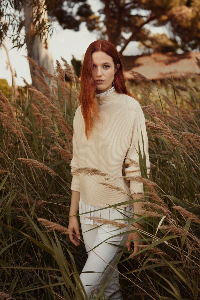 Pantalón blanco con camisa blanca y jersey en color beige. Todo de Lefties para un look minimalista.