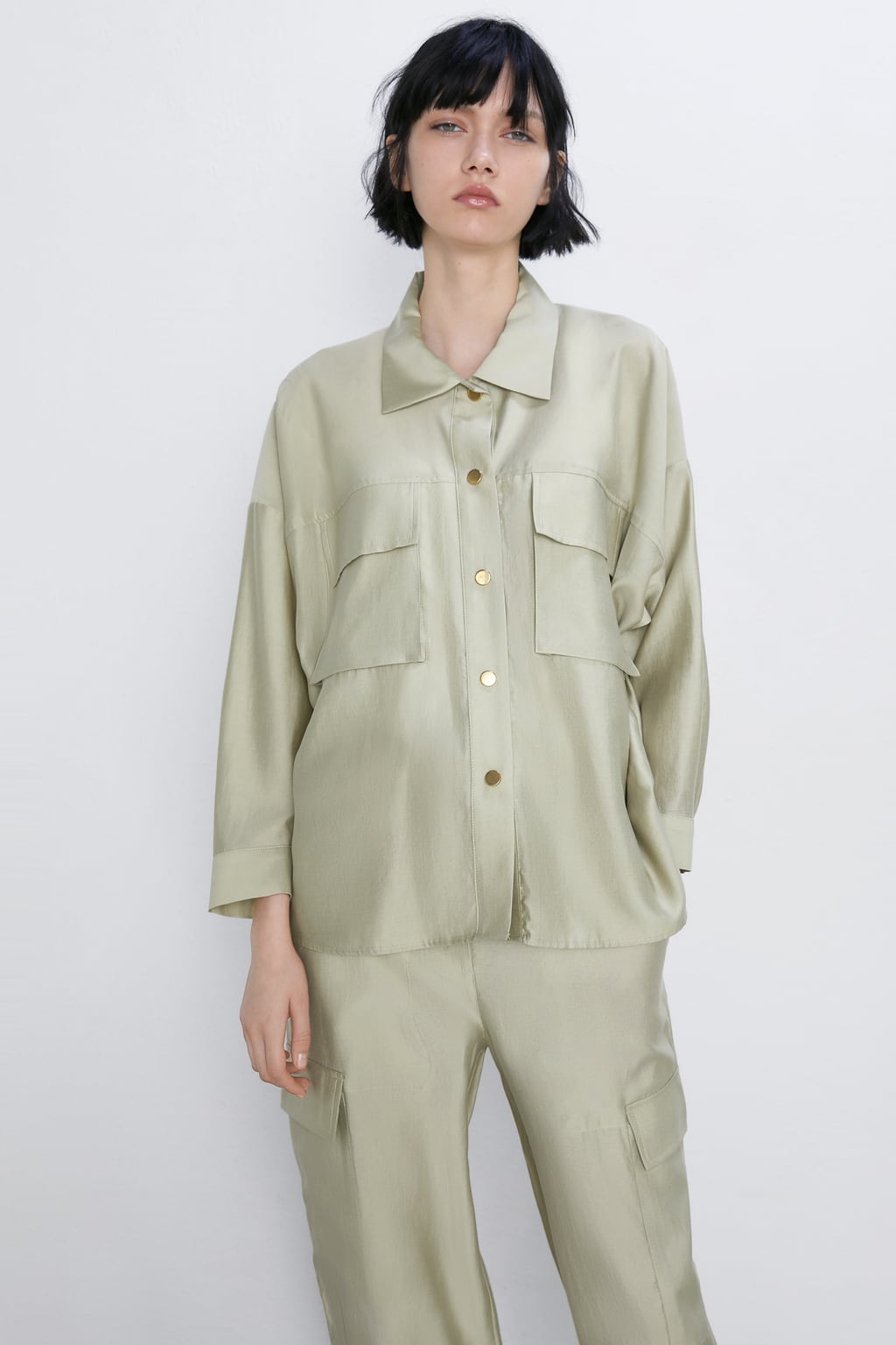 Sobrecamisa satinada verde kaki claro con bolsillos delanteros. ¿Te atreves con el total look? (39,95 euros).