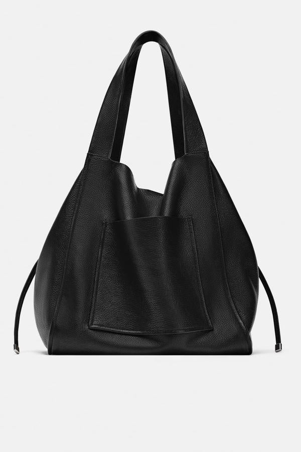 Bolso shopper de piel en color negro con tiras laterales y bolsillo exterior, 69,95 euros.