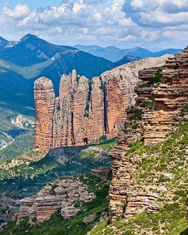 Desde él disfrutarán de las increíbles panorámicas de la Hoya de Huesca, los Mallos del Agüero, Peña Rueba o los Mallos de Riglos, todo un paraíso para los escaladores. Estas espectaculares formaciones rocosas, con paredes de hasta 272 metros de altura, nacieron fruto de la creación de la cordillera pirenaica y la posterior erosión de morrenas glaciares. Desde el Mirador de los Buitres se tiene una impresionante imagen de los Mallos de Riglos.