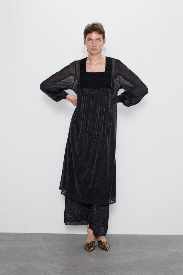 De la misma tela y con escote caja, las mangas te resguardarán del frío si es una boda de noche. Combínalo con accesorios discreto e incluso, como en la foto, lo puedes llevar con pantalón debajo. De Zara, (39,95 euros).