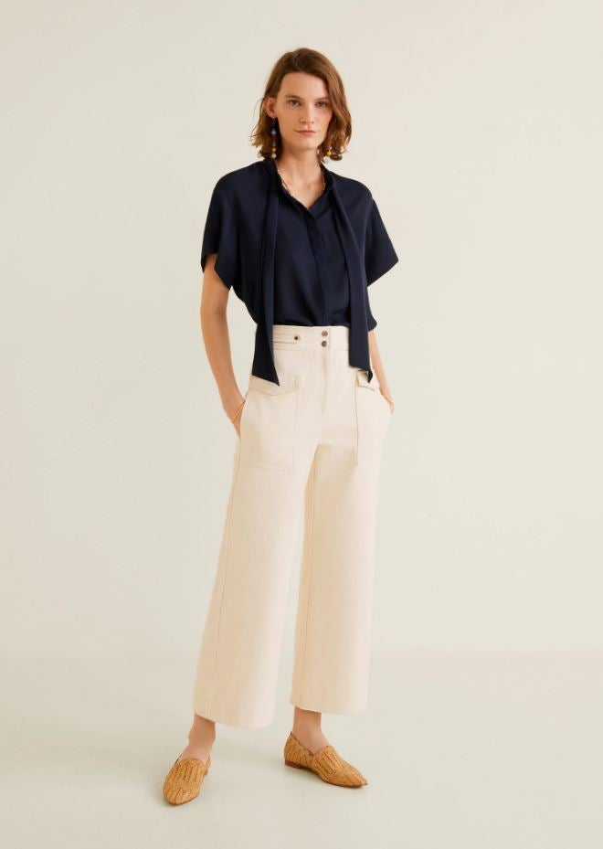 Esta sencilla blusa azul navy con detalle de lazo al cuello pasa de 29.99 a 19.99 euros en las rebajas 'mid season' de Mango.