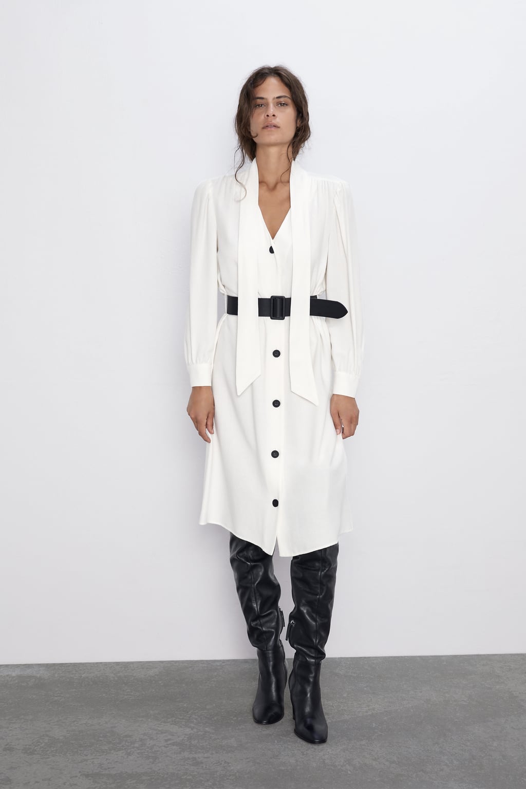 Vestido camisero blanco con lazada y cinturón ancho negro. (39,95 euros). ¿Cómo de bonito es el escote a pico?