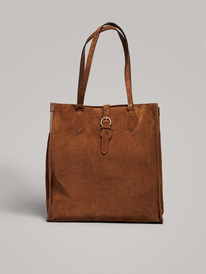 En Massimo Dutti hemos encontrado un maxi bolso de serraje que es perfecto para viajar con estilo llevando 'medio equipaje' al hombro y sin facturar (129 euros).