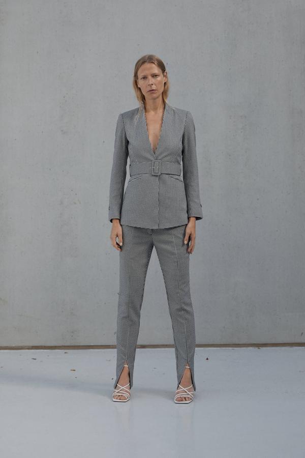 Traje de estampado de pata de gallo con pantalón con abertura en el bajo (29,99 euros) y americana con cinturón y sin solapas (49,99 euros) de Zara.