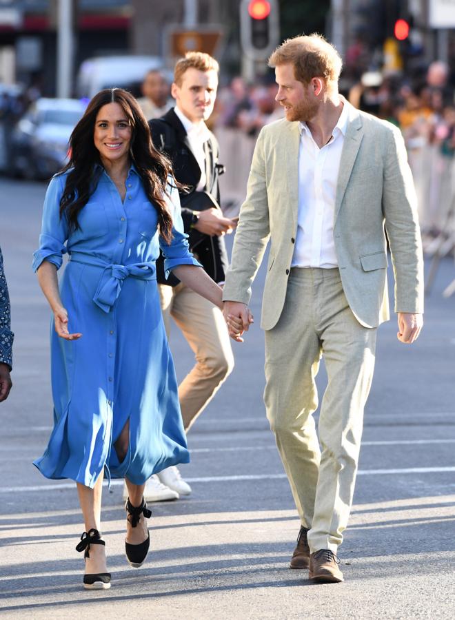 Durante su visita a Ciudad del Cabo, Meghan Markle lució un bonito vestido camisero azul cielo de Verónica Beard, un diseño midi abotonado que la Duquesa de Sussex  estrenó como look premamá en Toga  en octubre de 2018. Esta vez, lo ha combinado con sus alpargatas negras de cuña de Castañer.