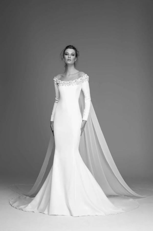 Vestido de crepé con canesú de tul y aplicación que rodea el cuerpo simulando escote barco. Manga larga y corte sirena.