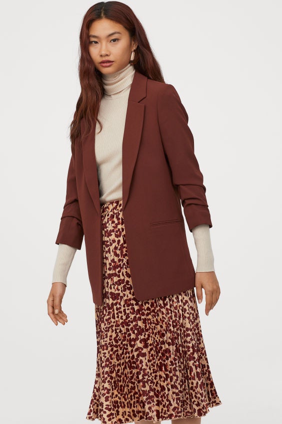 Americana color marrón teja y mangas fruncidas, la prenda perfecta para pasar del vestido de verano y al abrigo de invierno. Disponible en más colores. (39,99 euros).