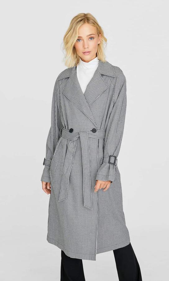 Antes de ponernos el abrigo, pasaremos por el clásico trench otoñal. Apuesta por este de pata de gallo, de Stradivarius (39,99 euros).