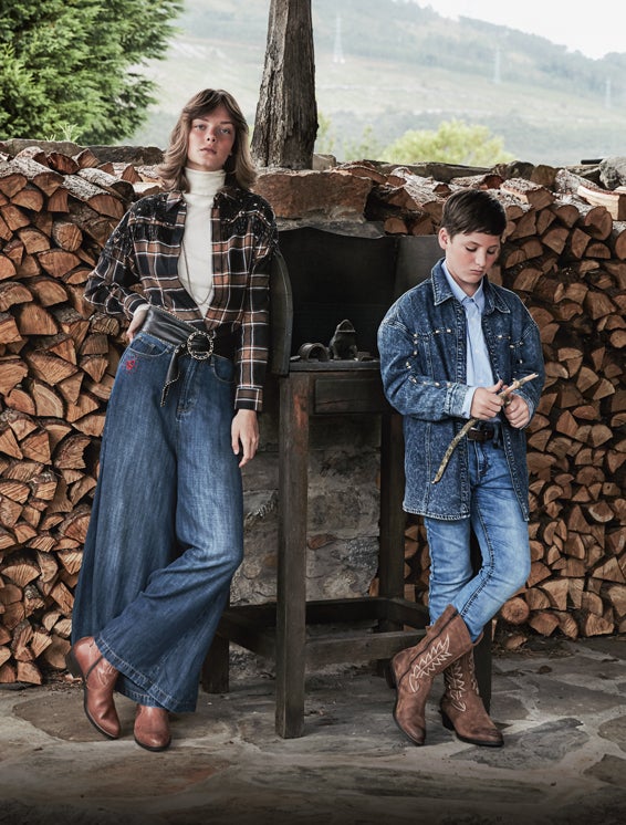 Ella lleva camisa de Sandro, jersey de cuello vuelto y pendientes de El Corte Inglés, cinturón de Chanel y cadena de Hermès. El niño, camisa vaquera de Kiabi, camisa a rayas de Mirto, pantalón de Primark y botas de Pitillos.