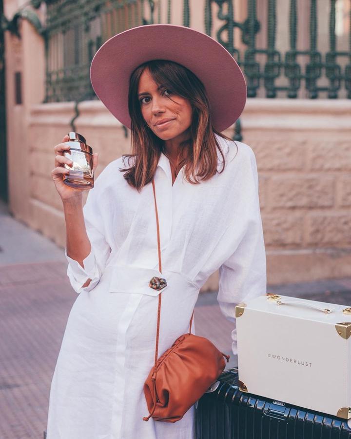 Con vestido de lino blanco, de Uterqüe.