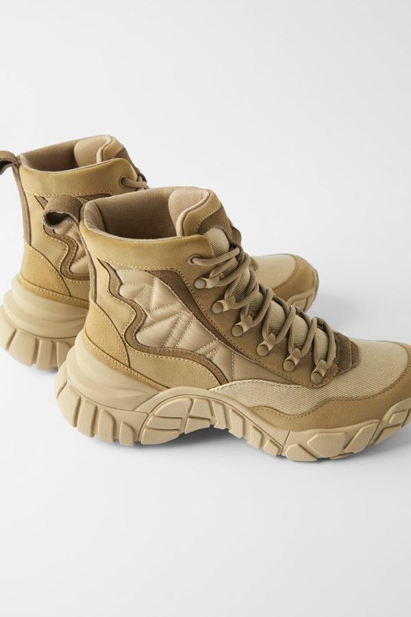 Botín montañero de Zara (49,95 euros) en una combinación de materiales en distintos tonos del color arena. Lleva suela dentada y tirador trasero.