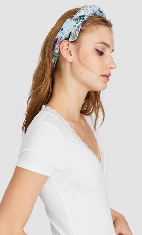 Si lo tuyo son los tonos claros también puedes apostar por una bandana plisada de flores que, como muestra la imagen, queda ideal a la hora de utilizarla como una diadema. También es de Stradivarius y cuesta 5,99 euros.