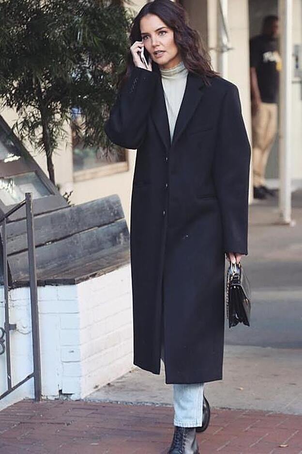 Katie Holmes luciendo un abrigo negro de estilo masculino con jeans rectos.