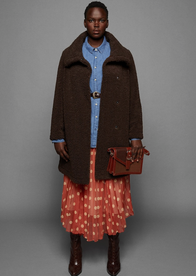 Abrigo de borreguito con cierre de botones a presión y bolsillos laterales (Violeta, 99,99 euros). Vestido de lunares rebajado en tejido fluido, con la falda de tables acampanada, tirantes finos y cierre con cremallera lateral (Violeta, 49,99 euros). Camisa de denim (Violeta, 29,99 euros), cinturón efecto serpiente con hebilla decorativa (Violeta, 15,99 euros). Bolso con solapa en tejido efecto serpiente, con asa desmontable y hebilla ajustable (39,99 euros). Bota de piel con efecto cocodrilo, con el tacón cuadrado de 9,5 centímetros (69,99 euros).