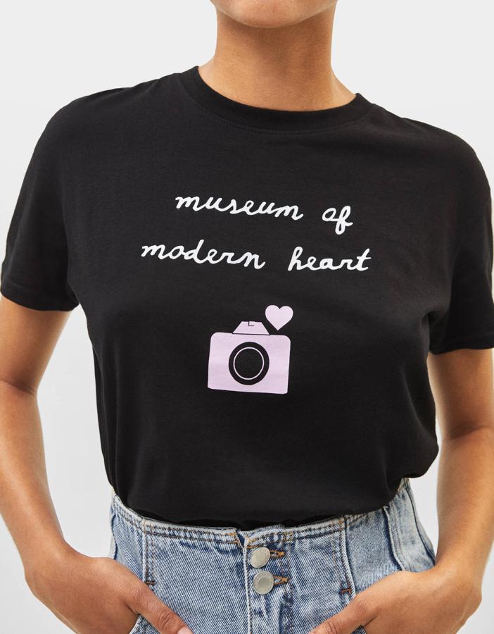 En color negro, con mensaje y una simpática cámara de fotos amorosas ocupando el frontal superior. Si te ha gustado su diseño recuerda, ¿cuándo ha sobrado una camiseta negra?