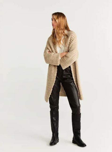 Juega con las texturas de tus looks más otoñales y crea combinaciones tan apetecibles como la que propone Mango: cárdigan de punto grueso (45,99 euros) con pantalones y botas de piel.