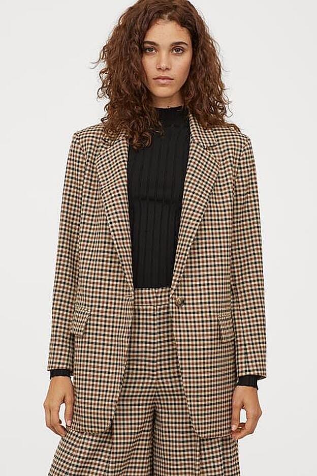 Fondo beige y cuadros marrones y negros en una de las versiones más clásicas de esta prenda. Americana de H&M (69,99 euros).