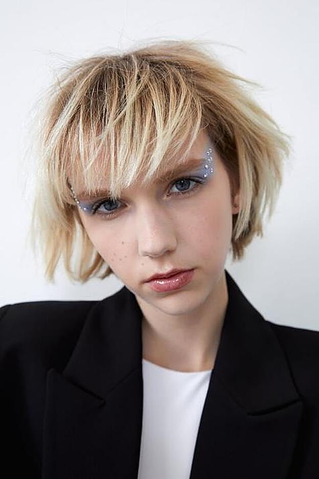 Maquillaje suave con cristales de colores y ahumado en color azul claro.