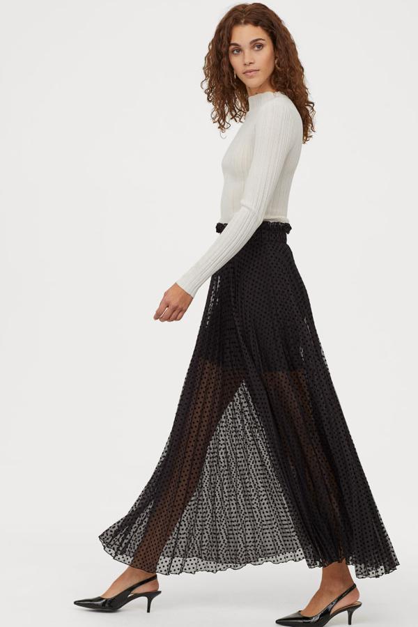 Espectacular falda plisada (49,99 euros), en gasa vaporosa con estampado de lunares. Lleva el talle alto con cintura elástica ancha ribeteada con un volante. Lleva la parte superior forrada.
