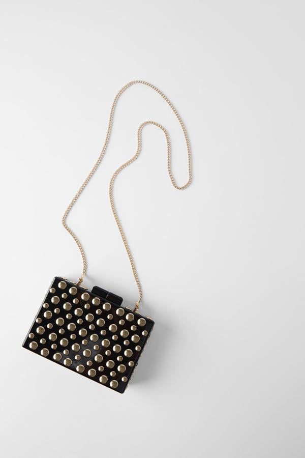Uno de nuestros favoritos es este formato caja de color negro adornado con tachuelas doradas de diferente tamaño. Tiene cierre de imán y puedes encontrarlo en Zara por 29,95 euros. Si te estás preguntando si te cabe el móvil, en su parte más larga mide 16 centímetros.