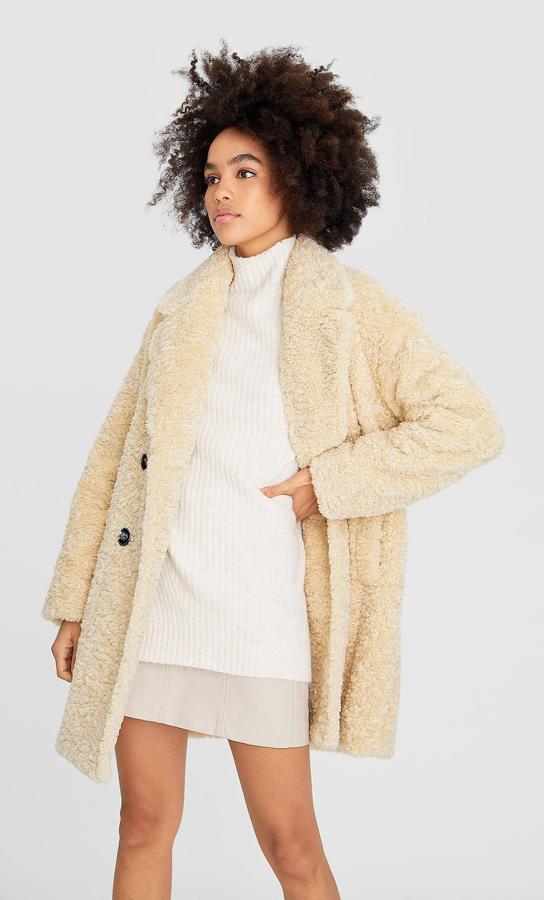 En Stradivarius apuestan por el clásico, por encima de la rodilla, botonadura cruzada y el rizo grande (49,99 euros).