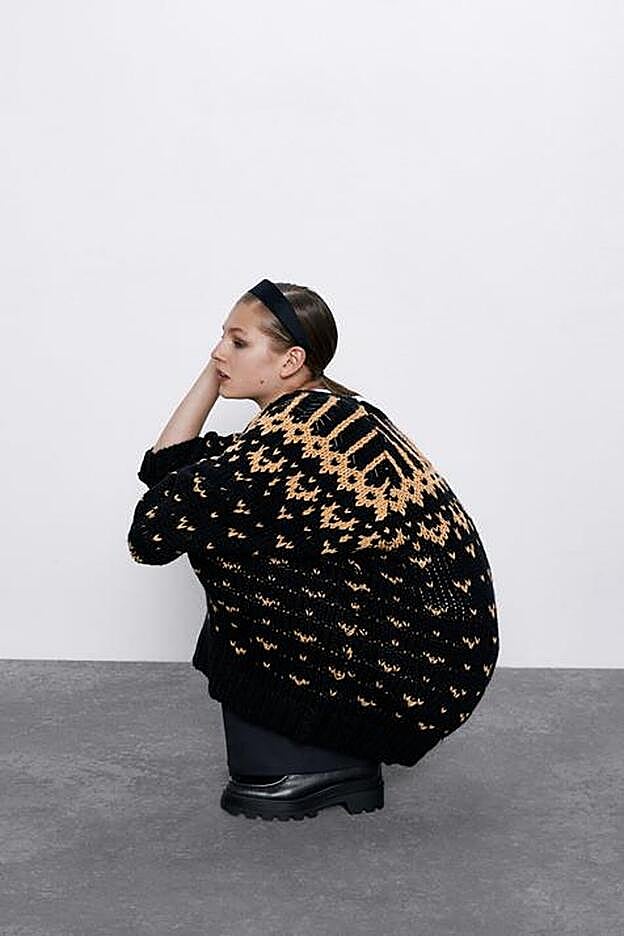 Jersey amplio negro con estampado en tono naranja de Zara.