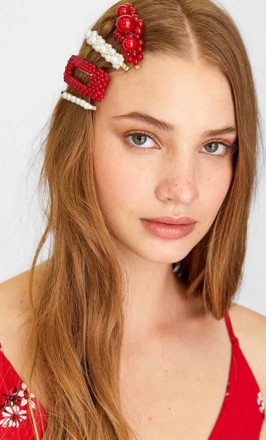 Para romper con los brillos, el negro y las lentejuelas, este set de Stradivarius incluye una pinza y un pasador en color rojo. Originalidad y elegancia que queda perfecto en cabellos negros y dorados por 7,99 euros.